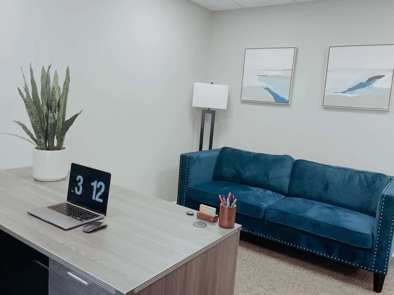 Office with a desk, laptop, and blue sofa at New Hope Healthcare Institute